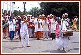 Kishores and youths dressed in traditional clothes jubilantly welcome Swamishri and the entourage of sadhus to the mandir