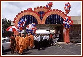 Kishores and youths dressed in traditional clothes jubilantly welcome Swamishri and the entourage of sadhus to the mandir