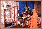 Swamishri gently rocks the Lord on a hindolo decorated with rakhadis