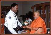 Police Commissioner, Mr. Coleman, greets Swamishri with a bouquet