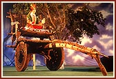 Beautifully decorated Utsav murti of Lord Swaminarayan on a traditional Indian cart