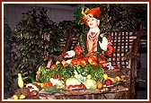 Lush, fresh vegetables before the Utsav murti seated on a traditional cart