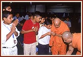 Placing his hand on the balak's shoulder, Swamishri listens to his enquiry with interest