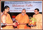 Tying an auspicious cloth on the 'Nidhi kumbh' and placing it in the foundation pit during the Shilanyas Ceremony