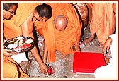 Tying an auspicious cloth on the 'Nidhi kumbh' and placing it in the foundation pit during the Shilanyas Ceremony