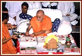 Performing Vedic pujan of the stones to be laid in the foundation with kumkum, flowers and panchamrut