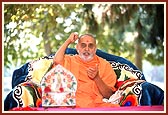 Swamishri happily responds with gestures during the singing of a bhajan that describes the water - leela of Shriji Maharaj in Amdavad: "Rang Bharela Lalji, Jalma Jhile Balvir ..."