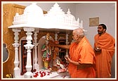 Swamishri performs pujan and arti of Thakorji installed in a ghar mandir at a devotee's house 