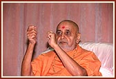 Swamishri gestures during a kirtan sung in the assembly