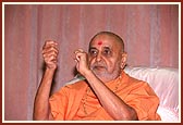 Swamishri gestures during a kirtan sung in the assembly