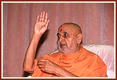 Swamishri gestures during a kirtan sung in the assembly