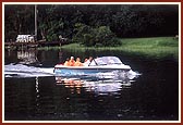 Swamishri offers two sanctified flowers into the lake and a prayer for the salvation of all living things in the lake 