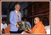 Swamishri receives a plaque of honor from Mr. John Hogan, President of Kiwanis International Club 