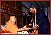 Swamishri presents a gift to Mr. Jacob Chacko, Chief Security Officer, UNO