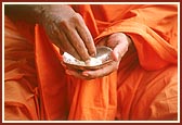 Ashirvad: Swamishri blesses the devotees by sprinkling rice grains