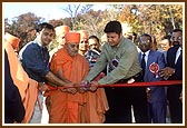 Swamishri and sponsors, Shri Mayurbhai and Shri Nimeshbhai, cut the ribbon to inaugurate the archway