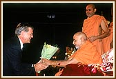 Mr. Douglas Hoeft, State Representative, offers a bouquet to Swamishri