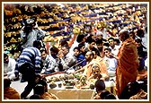 Swamishri during maha-puja with Annakut arrangement in the background 