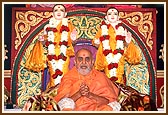 Swamishri blessing the audience with the murti of Akshar Purushottam Maharaj in the backdrop