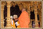 Swamishri holds a mirror during the murti pratishtha ceremony