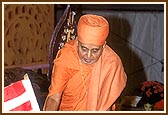 Swamishri gives a flag to a balak during their march