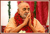 Swamishri in a humble gesture after being honored with a garland for his historic Satsang tour abroad