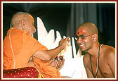 Swamishri applies chandan on Priyesh Patel (Kapil Bhagat) while initiating him into parshad-fold