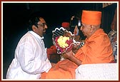 Shri Bharat Shah, President of the Indian Association of Dubai, welcomes Swamishri with a bouquet