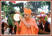 Swamishri joins the festive ambience and reciprocates the tribal devotees' love by striking a brass dish with a stick