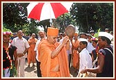 Swamishri joins the festive ambience and reciprocates the tribal devotees' love by striking a brass dish with a stick