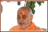 Swamishri performs his morning puja with the Shri Swaminarayan Mandir, Sankari in the backdrop