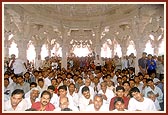 Devotees doing darshan during arti beneath the mandir dome