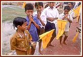 Udiya satsangi children wave the flags as a gesture of welcome