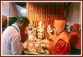 Swamishri blesses Shri Divyasinghdev and devotees by showering rice grains