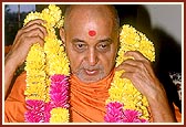 Swamishri is garlanded after puja