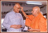 Swamishri welcomes and offers a gift to the Governor Shri Dineshnandan Sahay