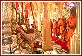 Swamishri gently rocks Thakorji in a hindolo