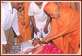 Swamishri places a teaspoonful of holy water in Prabhudasbhai's mouth 