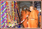 Swamishri gently rocks Thakorji in a hindolo 