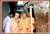 Swamishri sanctifies and observes the newly acquired homes adjacent to the Smruti Mandir 