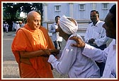 Swamishri patiently enquires the wellbeing of an aged devotee and blesses him&nbsp;