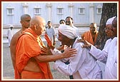 Swamishri patiently enquires the wellbeing of an aged devotee and blesses him&nbsp;
