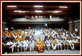 Swamishri and guests view a visual presentation in the Institute's auditorium