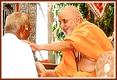 Swamishri cordially meets and blesses a devotee