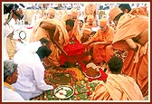 Swamishri engaged in the installation of the principal shila in the foundation