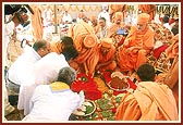 Swamishri engaged in the installation of the principal shila in the foundation