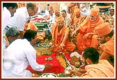 Swamishri engaged in the installation of the principal shila in the foundation