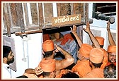 Swamishri respectfully touches the staircase of Goverdhanbhai Sheth's house that was sanctified by Shriji Maharaj