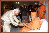 Shri Dhirubhai Nanji Mehta welcomes Swamishri with a bouquet 