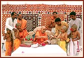 Swamishri ritually applies chandan and gives the janoi to Brahmin batuks